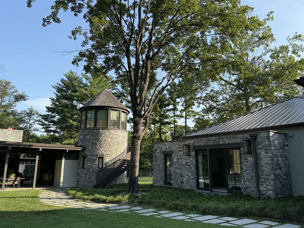 Stone pool house with a round glass tower