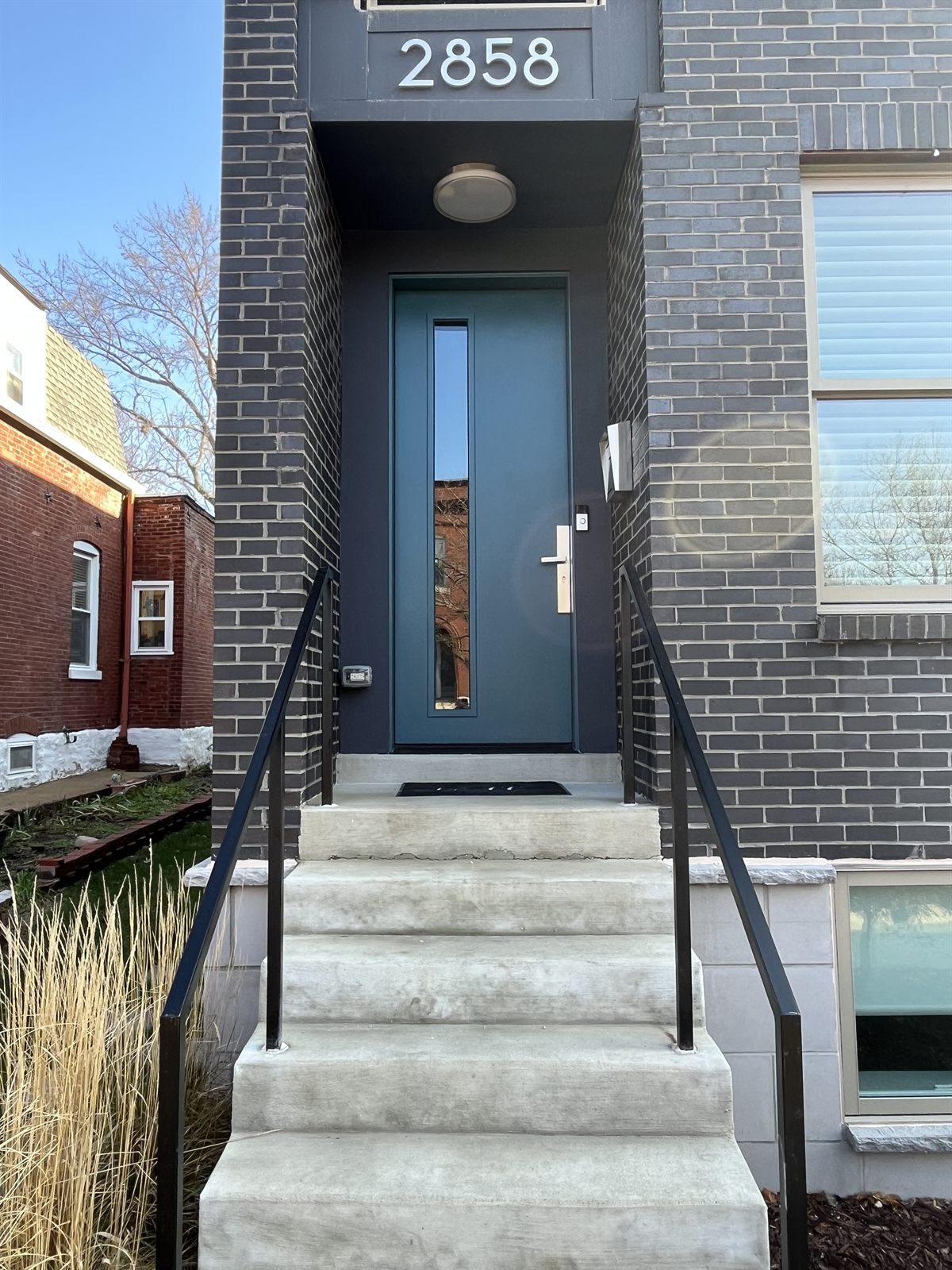 Modern blue entry door on a St. Louis city home