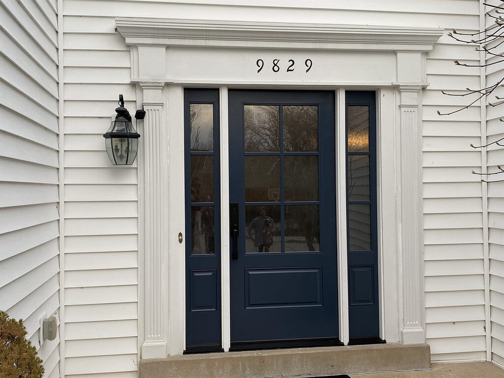 Navy entry door with sidelites on a colonial home