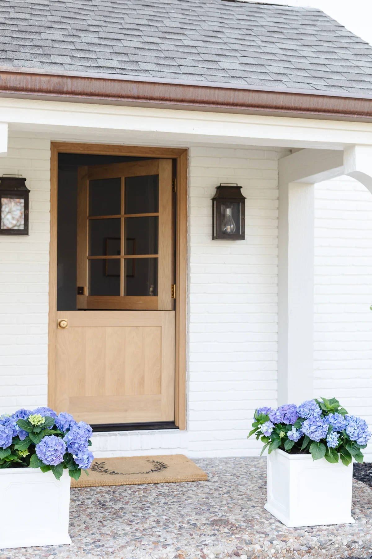 White oak dutch door on a white brick home, installed by Webster Window and Door